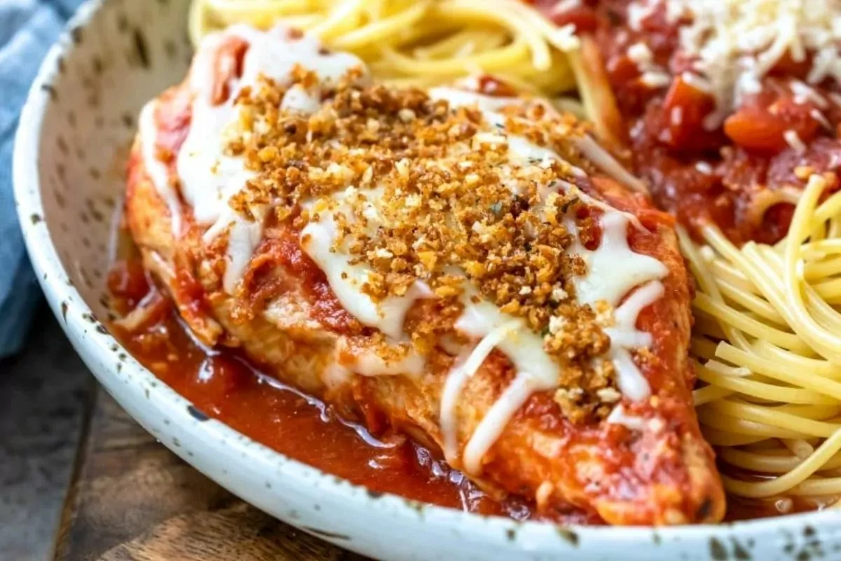 Chicken parmesan on plate with spaghetti.