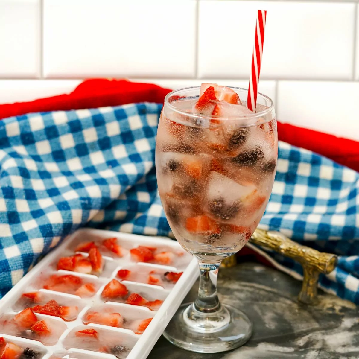 blue gingham cloth with beverage and ice cube tray.