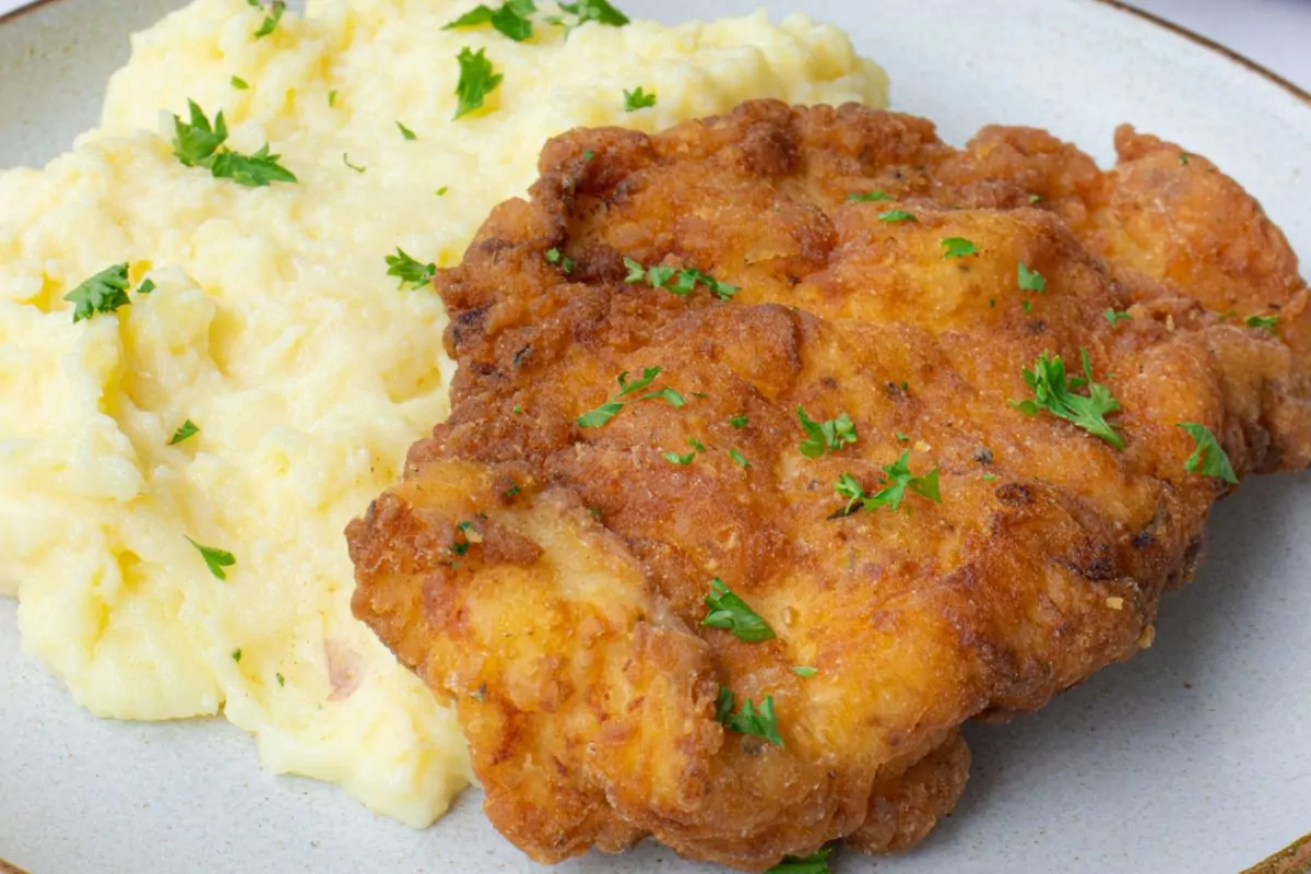 mashed potatoes and fried chicken on gray plate.