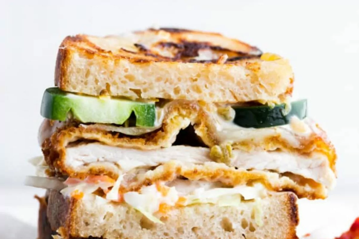 thick sliced sandwich with veggies and chicken.