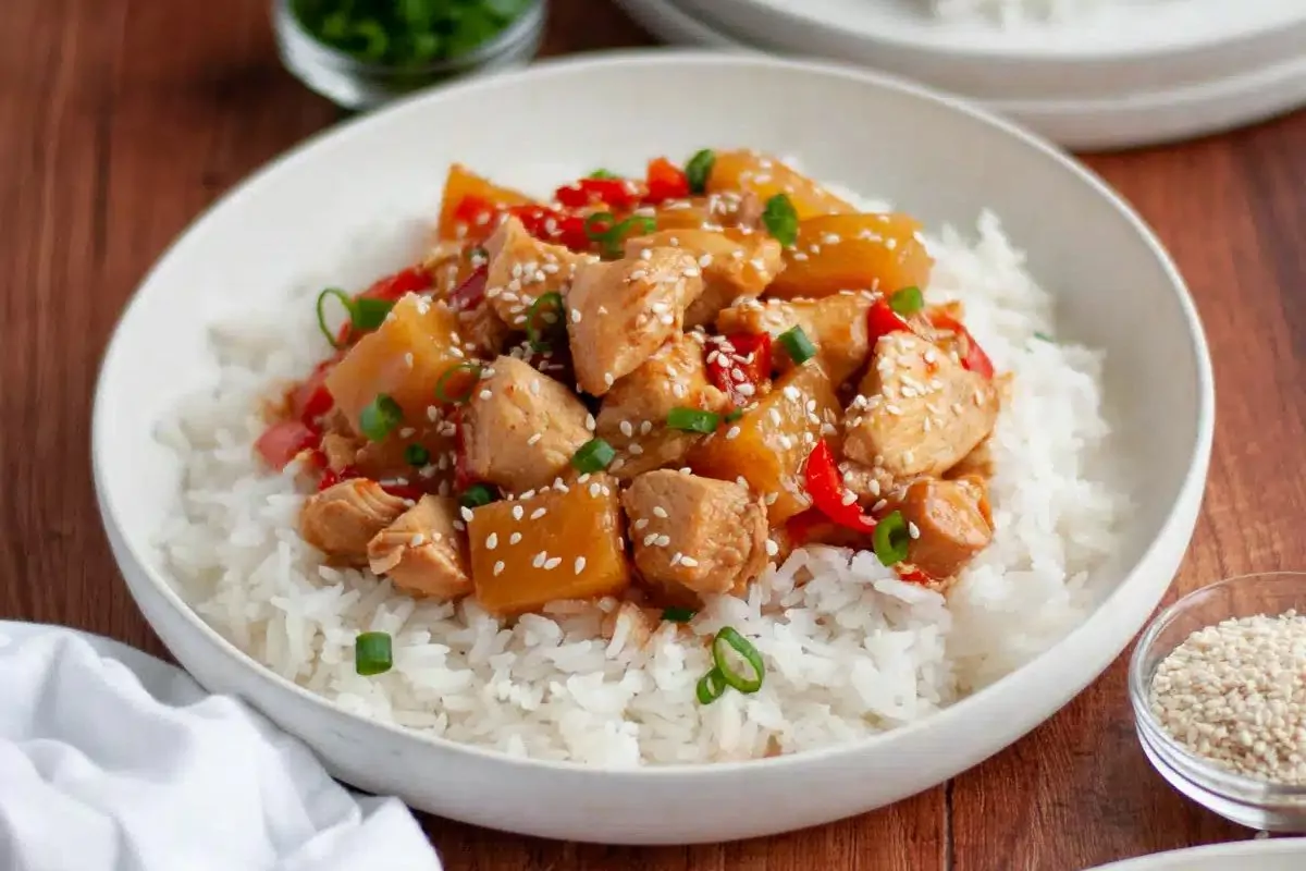 cooked chicken in chunks on top of white rice.
