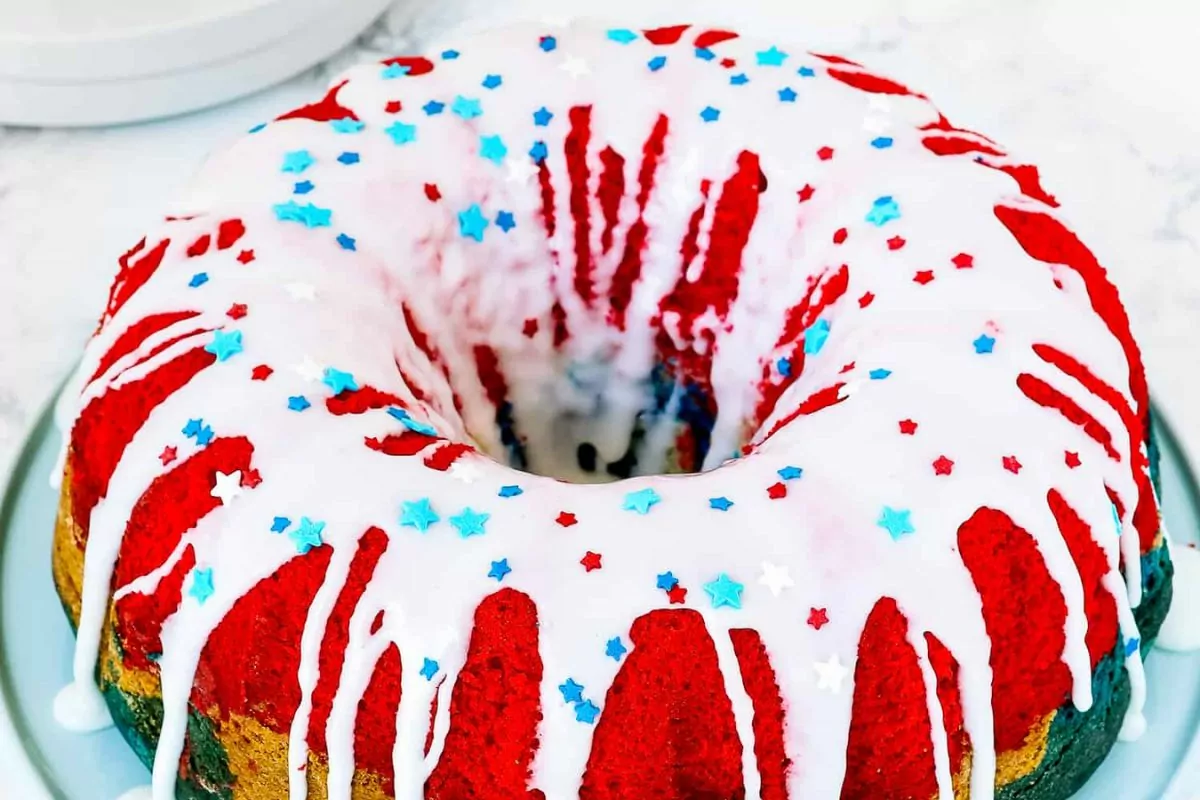 Festive 4th of July Bundt cake decorated with white frosting and patriotic sprinkles.