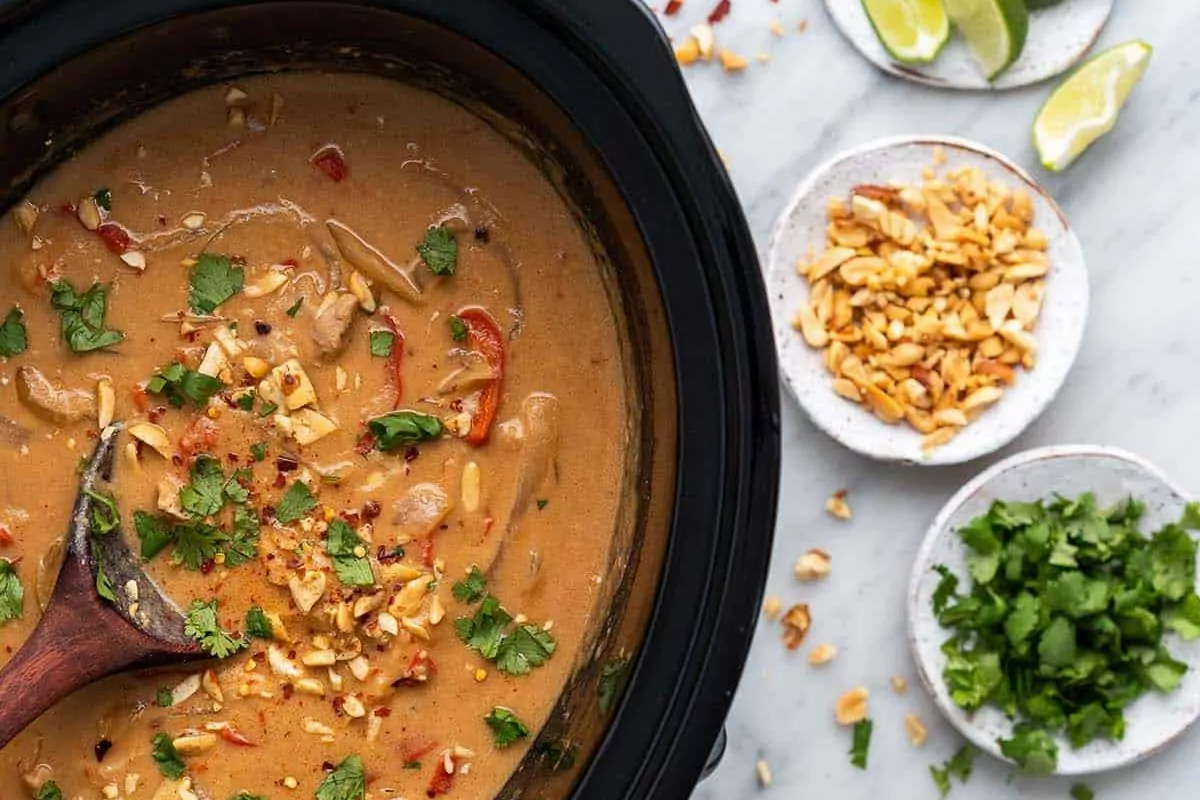 crock pot with peanut sauce and chicken.