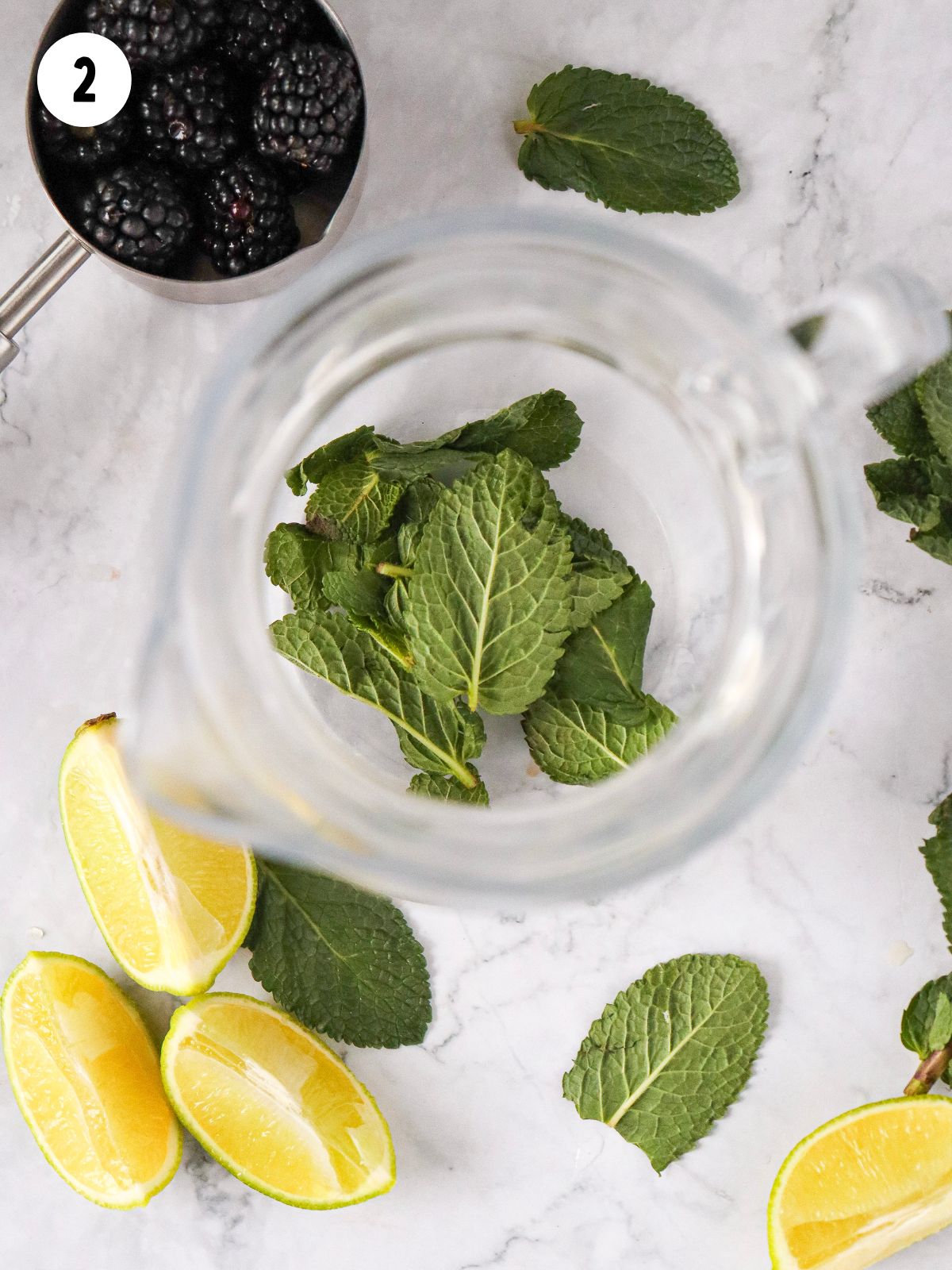 mint leaves with lime wedges in pitcher.