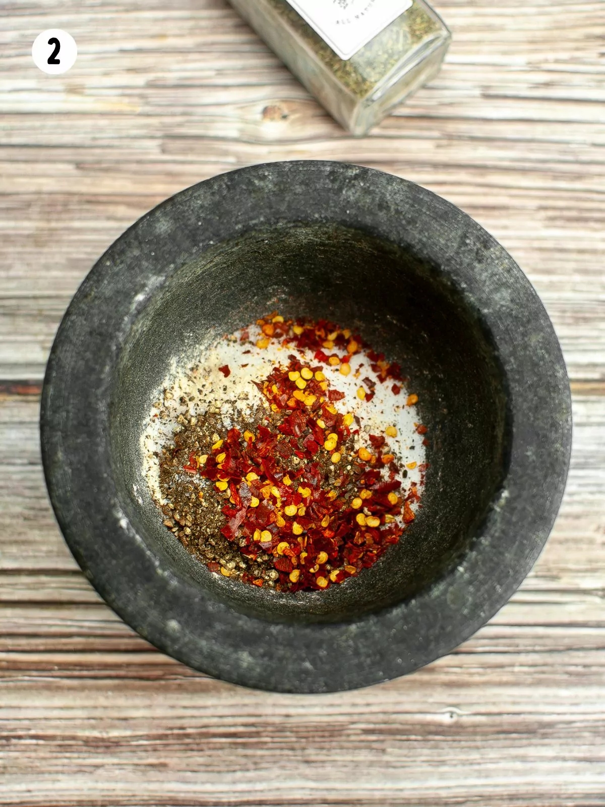 red pepper flakes with herbs in bowl.