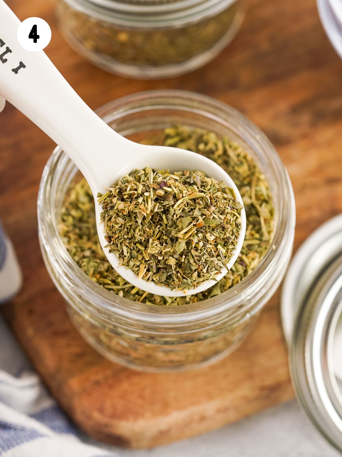 teaspoon filled with seasoning blend over small mason jar.