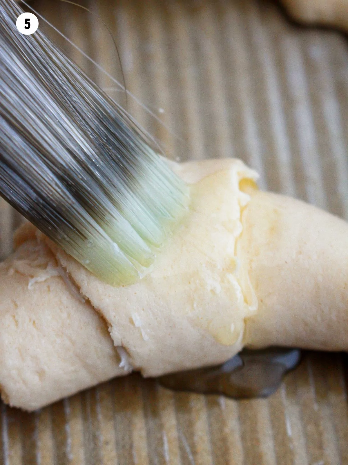 brushing melted butter on top of crescent roll before baking.