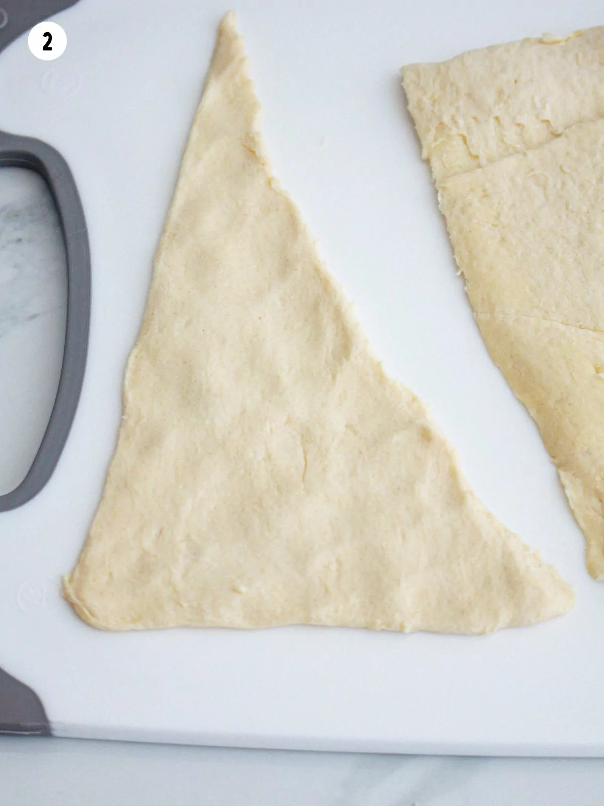 separated triangle of crescent rolls on cutting board.