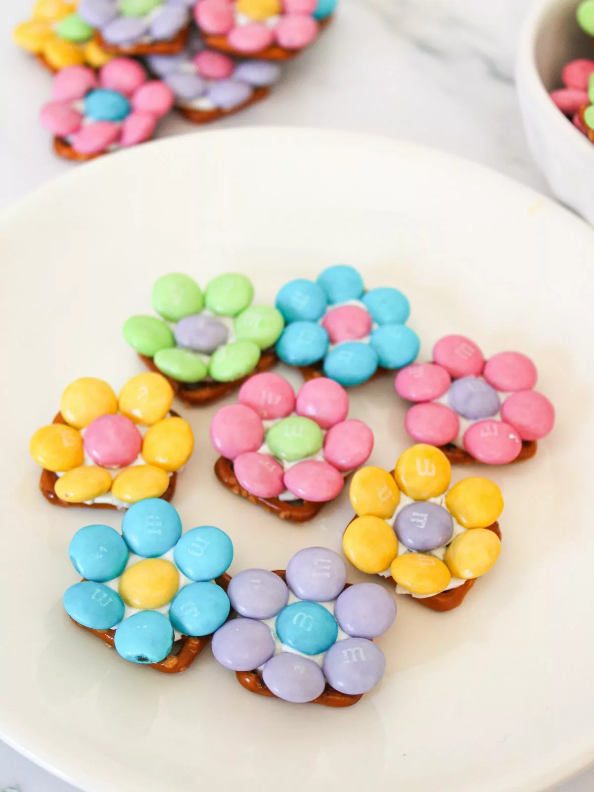 candy flower pretzels on white plate.
