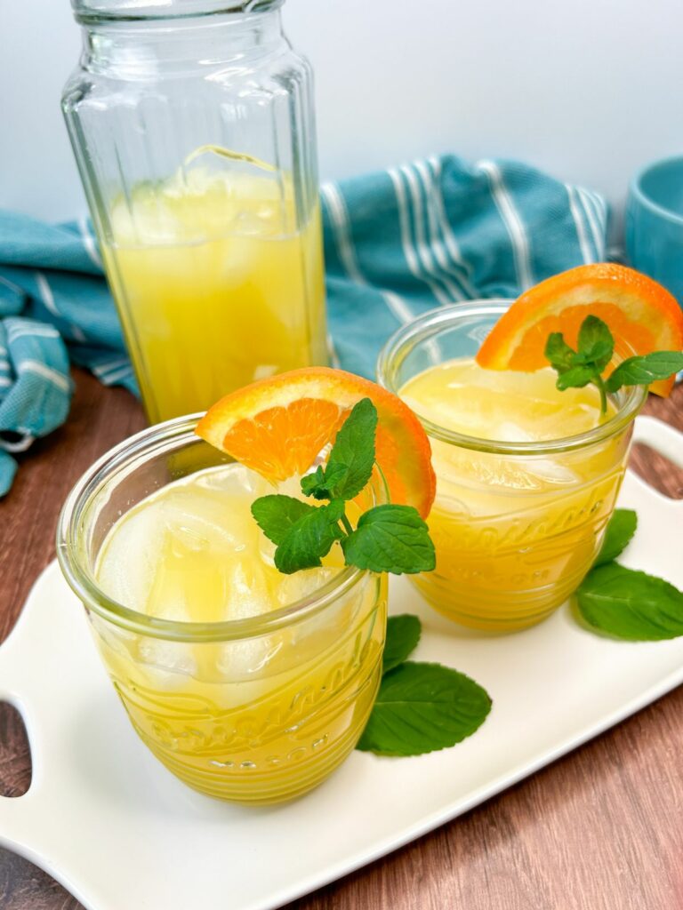 Coconut Water and Orange Juice served with an orange wedge on the side of the glass