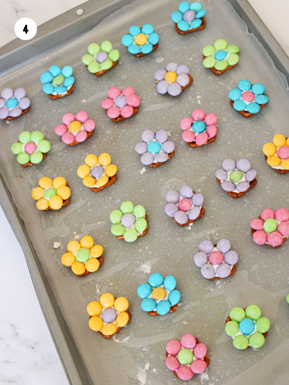 pretzels with pastel colored M&Ms on baking tray.