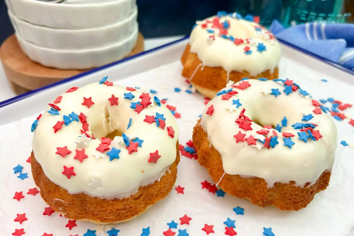Mini bundt cakes decorated with cream cheese frosting and star sprinkles.