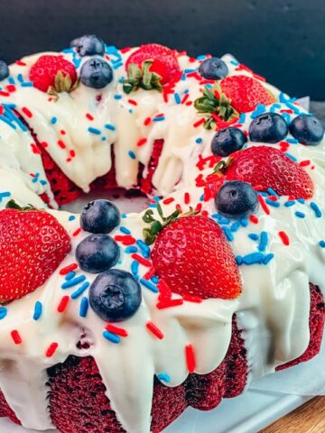 red velvet Bundt cake with strawberries, blueberries and sprinkles.