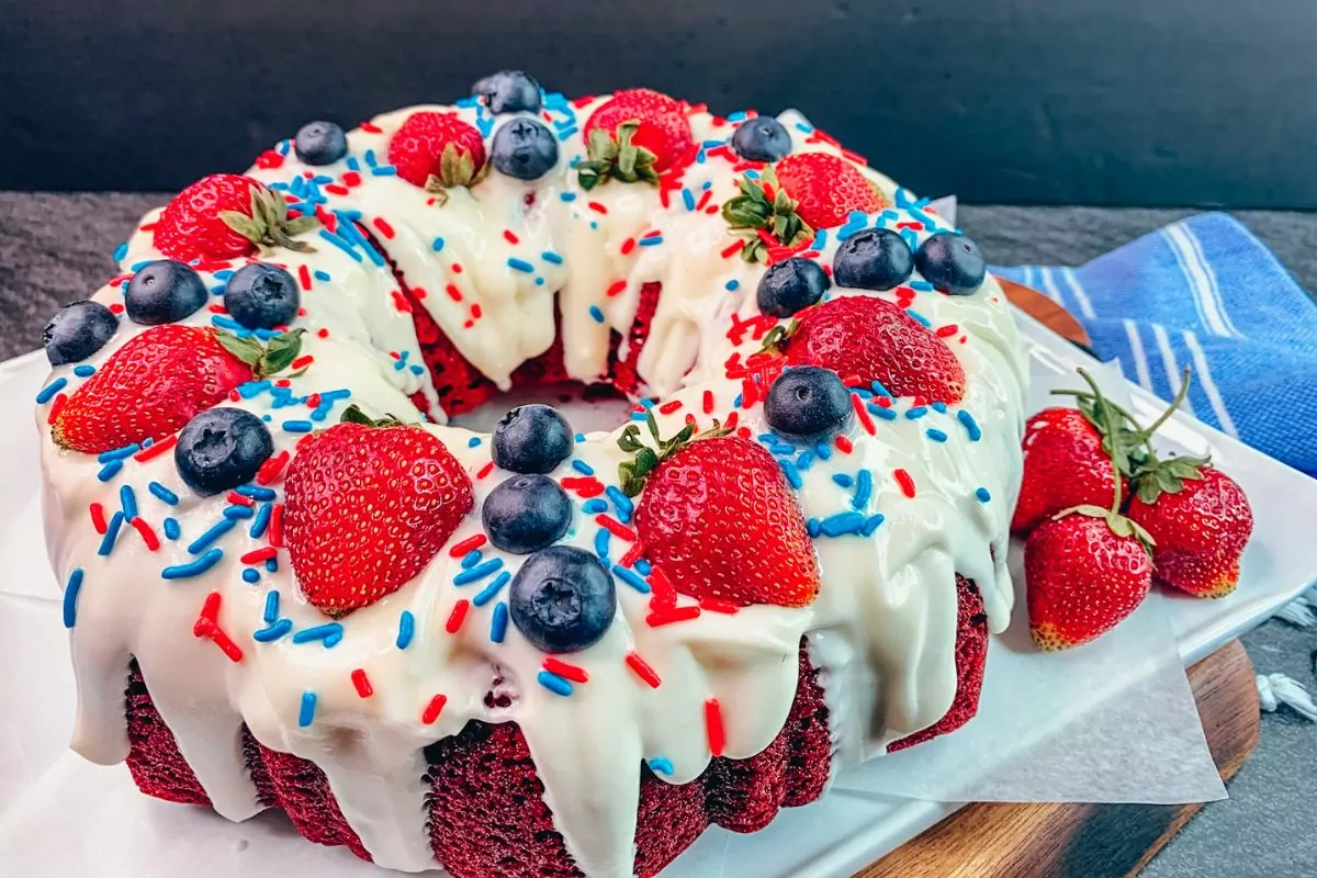 red velvet Bundt cake with strawberries, blueberries and sprinkles.
