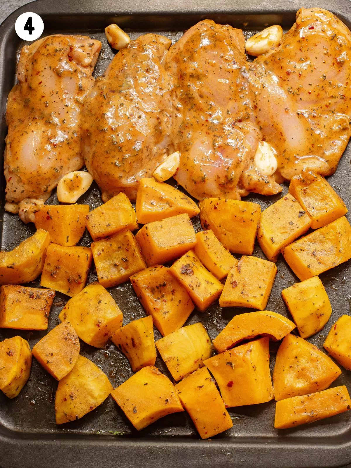 raw chicken on baking tray with squash.