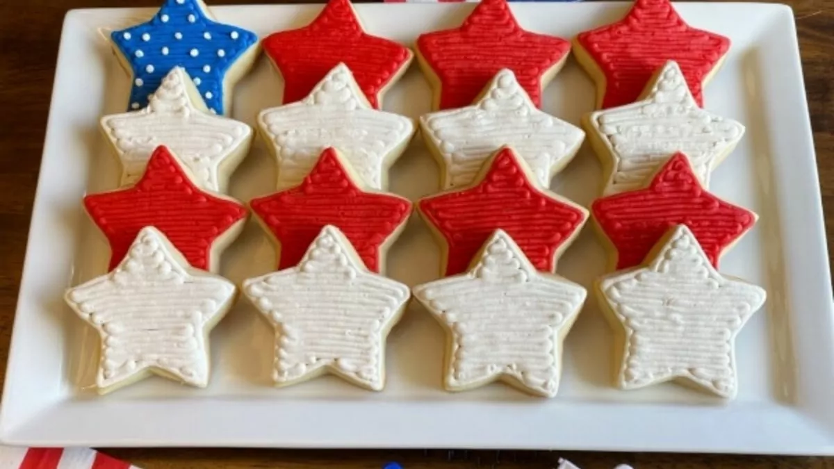 Star shaped sugar cookies frosted in red, white and blue, arranged to look like a tasty flag.