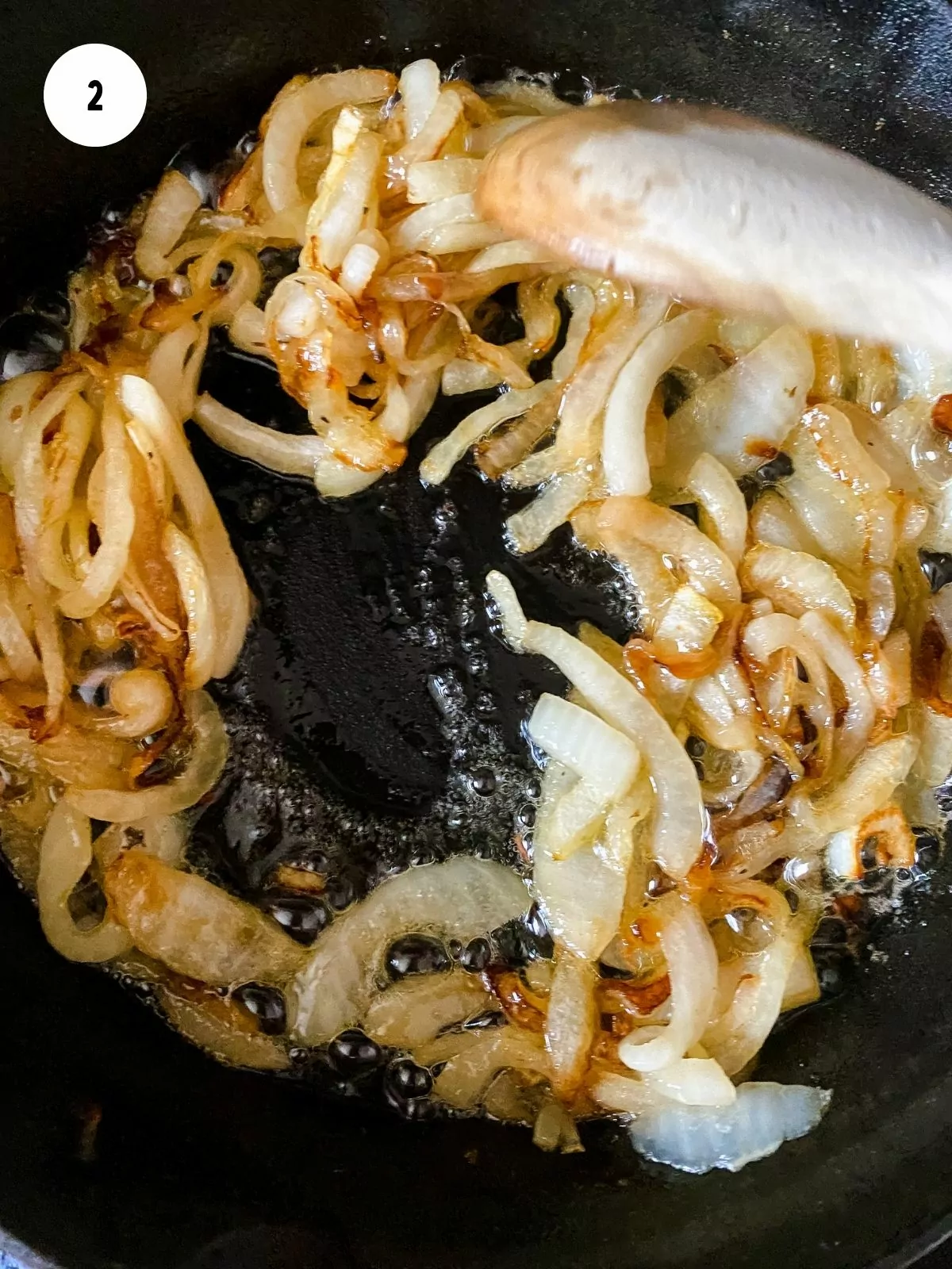 Onions being caramelized in a cast iron pan