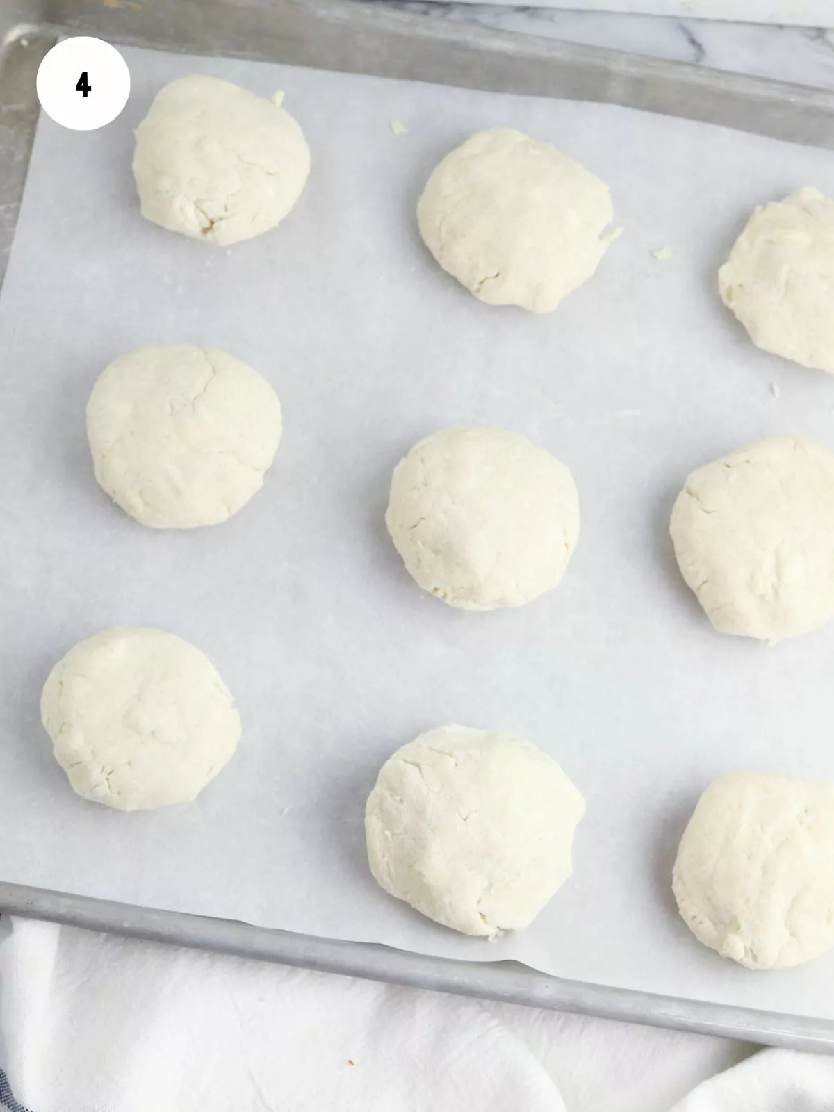 Balls of dough on a baking sheet lined with parchment paper