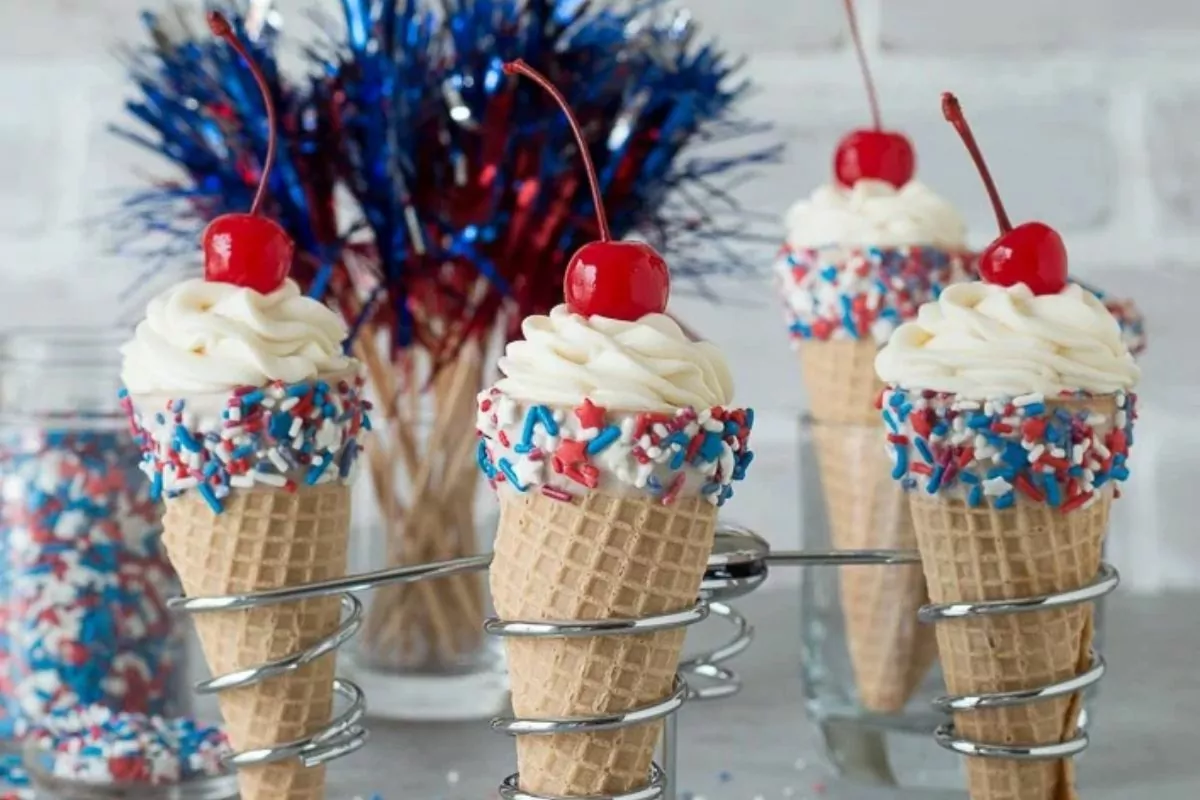 wafer ice cream cones with cheesecake frosting, sprinkles and a cherry.