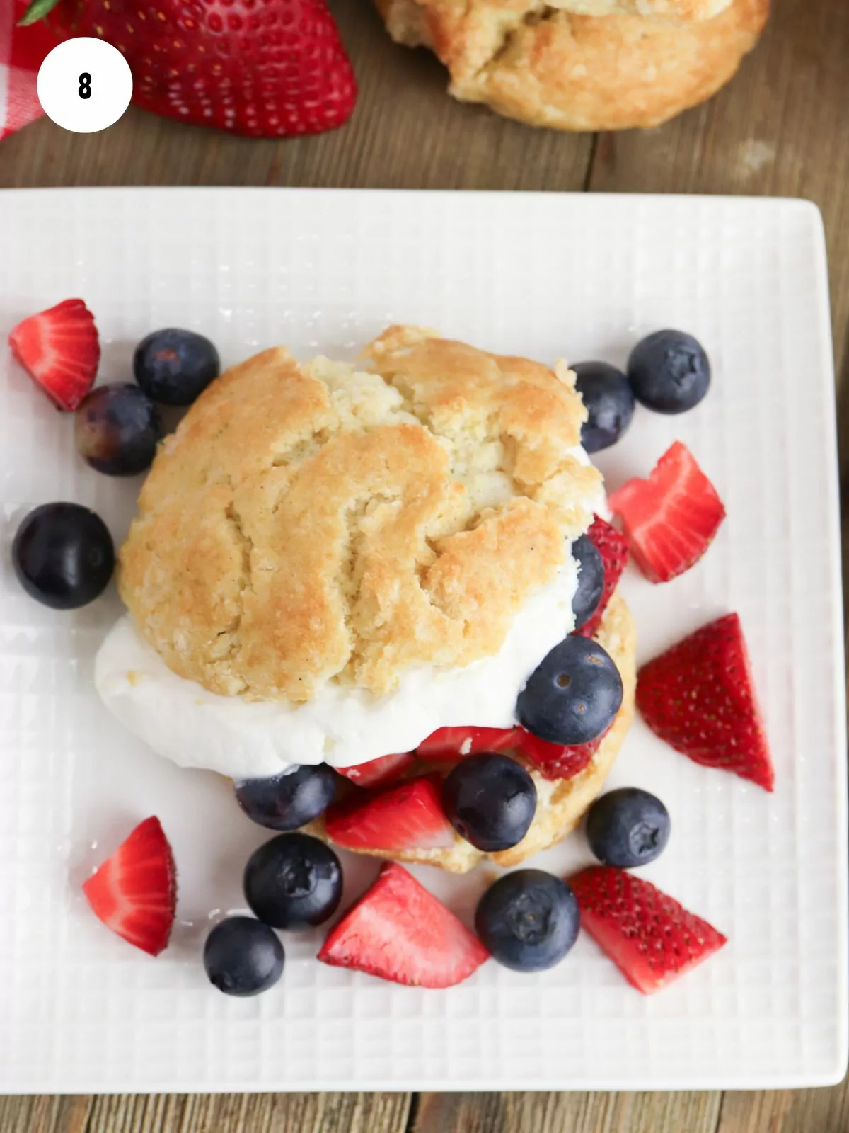 Shortcake cut in half and filled with whipped cream and fresh strawberries and blueberries