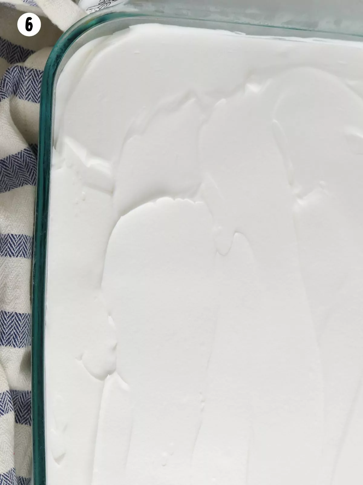 Cool Whip whipped topping spread on baked cake.