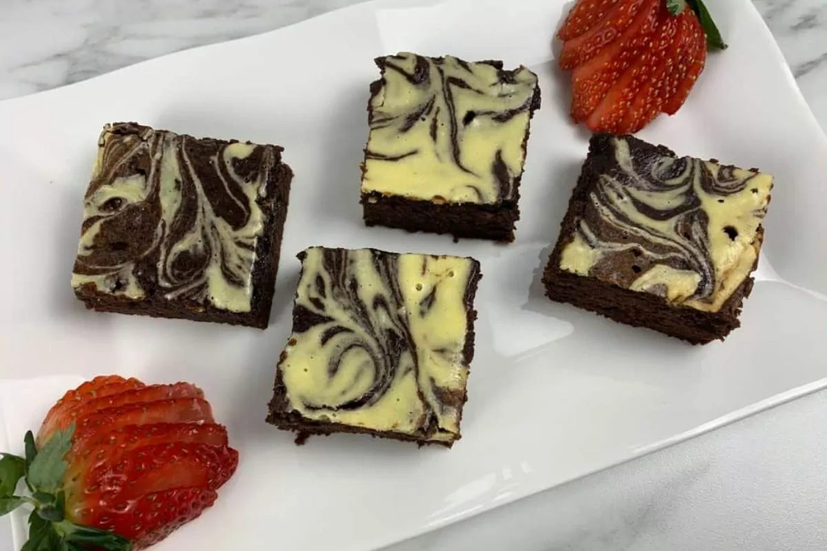 cream cheese brownies on plate with strawberries.