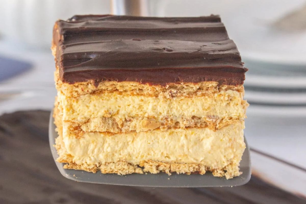 A serving of chocolate eclair icebox cake being lifted from the pan.