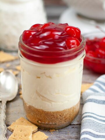 mason jar of Cool Whip and Cheesecake Pudding topped with cherry pie filling
