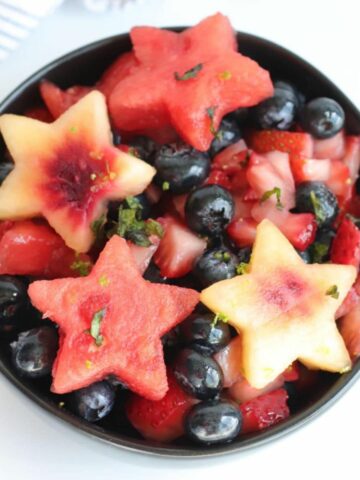 fruit salad with fruit cut in star shapes on top by Restless Chipotle