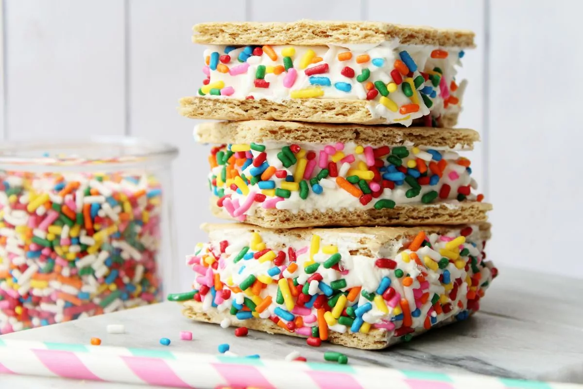 stacked frozen Cool Whip graham cracker sandwiches with rainbow sprinkles.