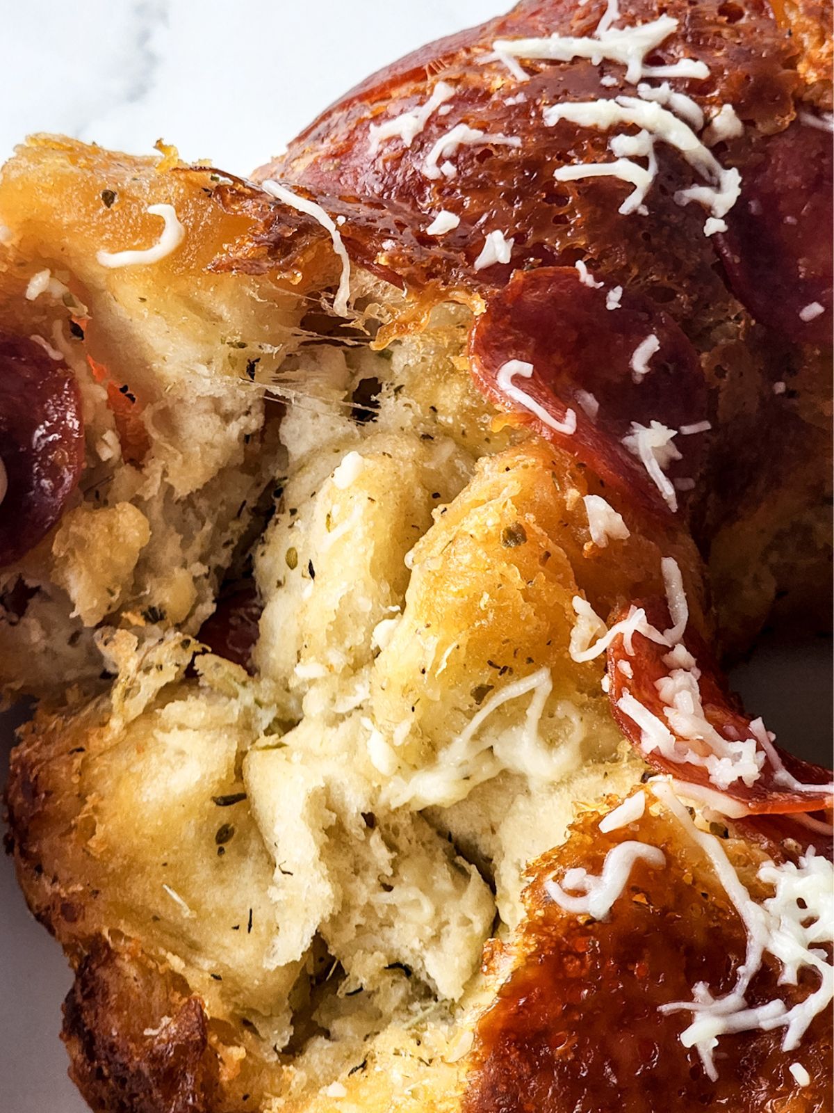 close up of baked refrigerator dough biscuits with cheese, spices and pepperoni.