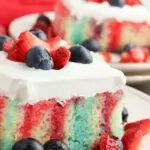 Close-up of a slice of patriotic poke cake, revealing vibrant red and blue streaks from Jell-O.