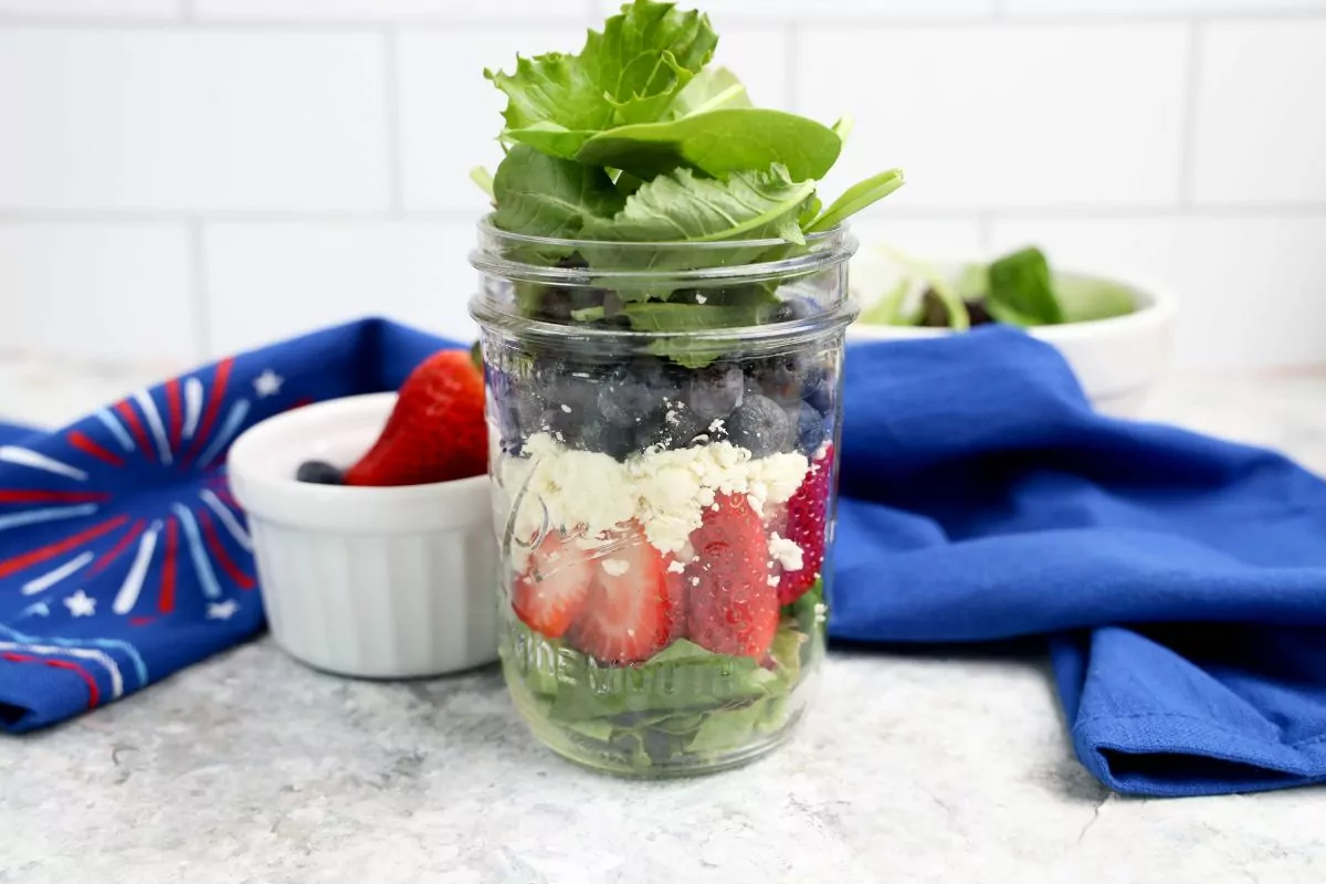 Patriotic Salad in a Mason Jar with a blue towel in the background