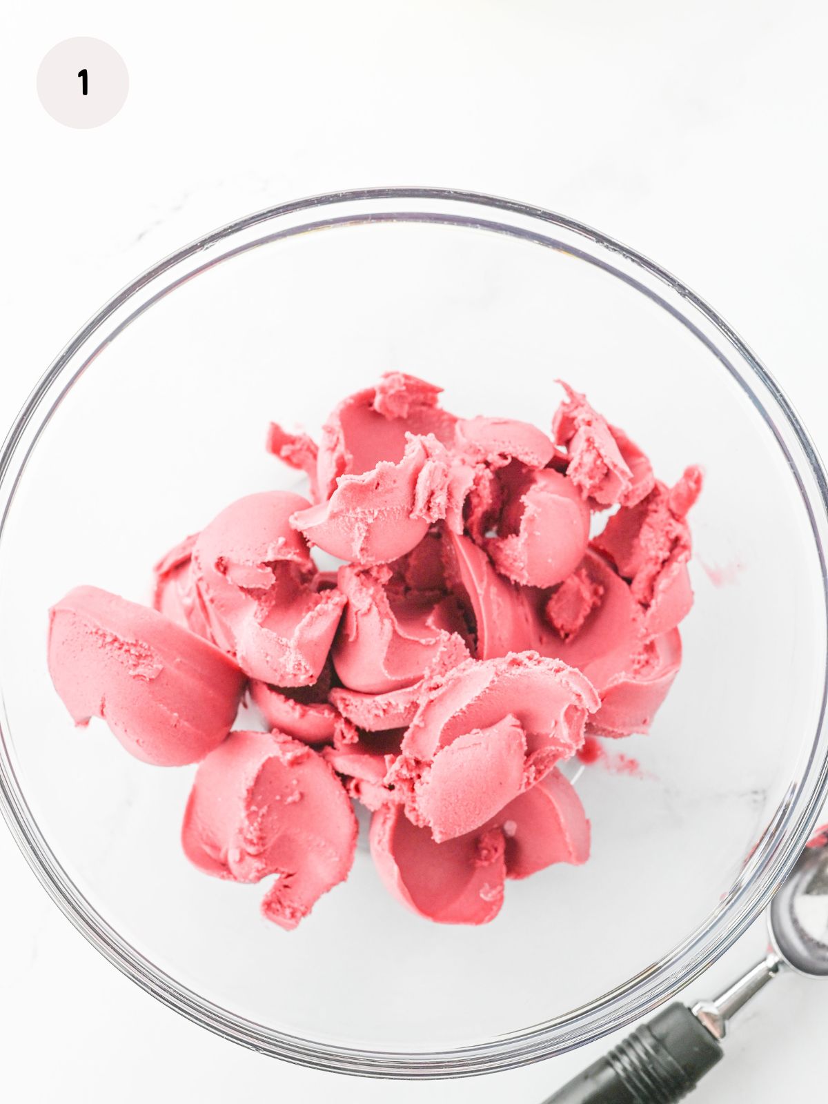 scoops of raspberry sorbet in a clear punch bowl