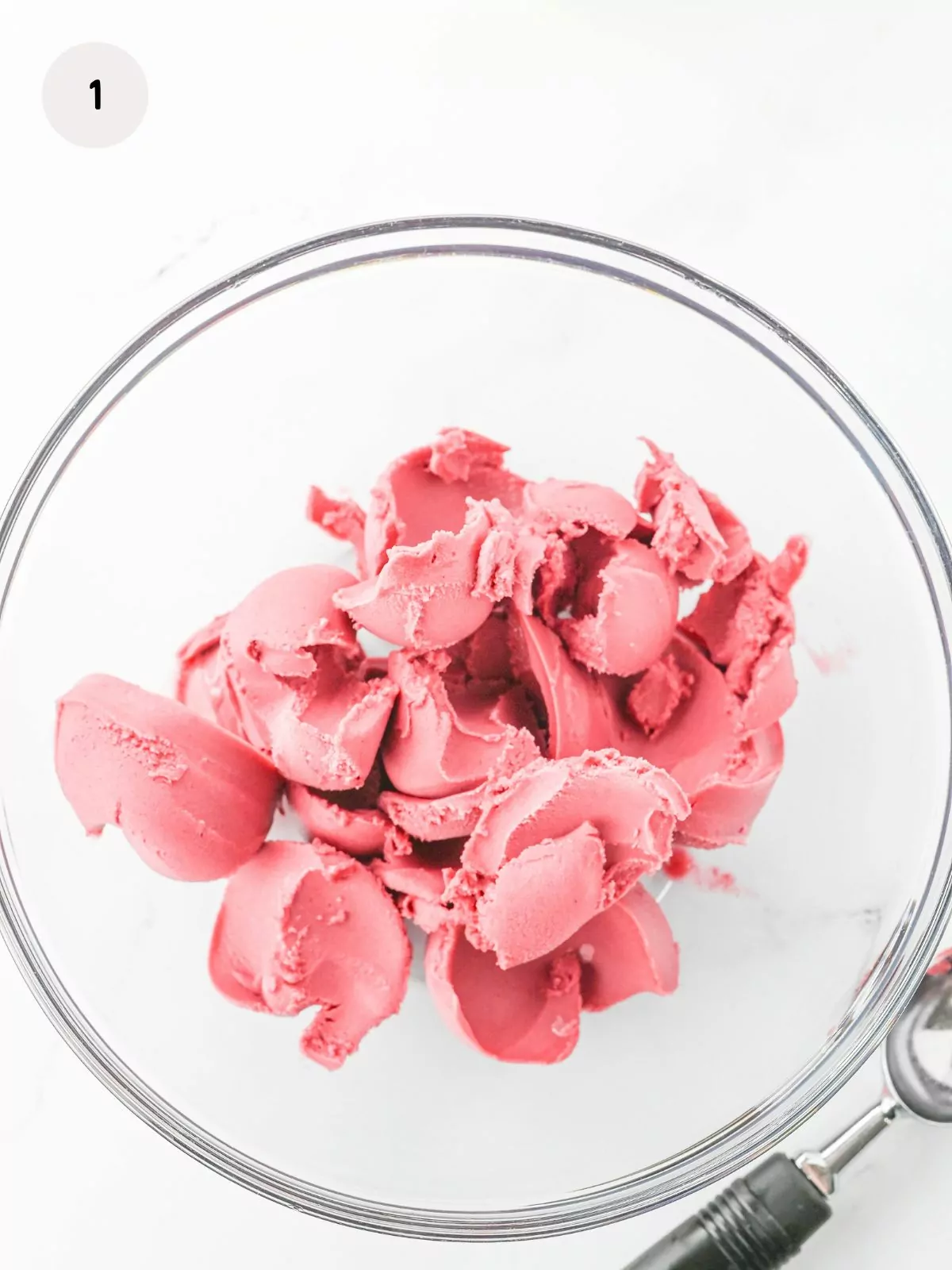 scoops of raspberry sorbet in a clear punch bowl