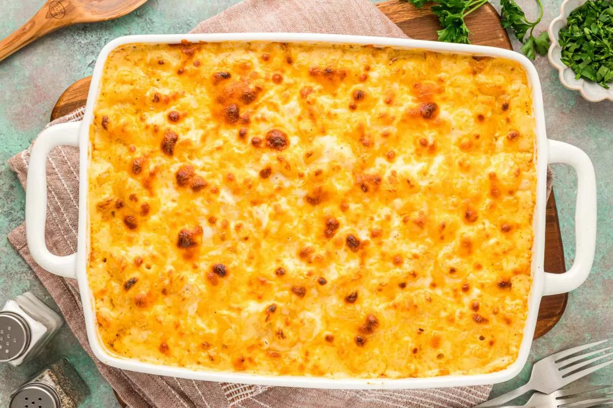 a serving dish of mac and cheese with a wooden spoon.