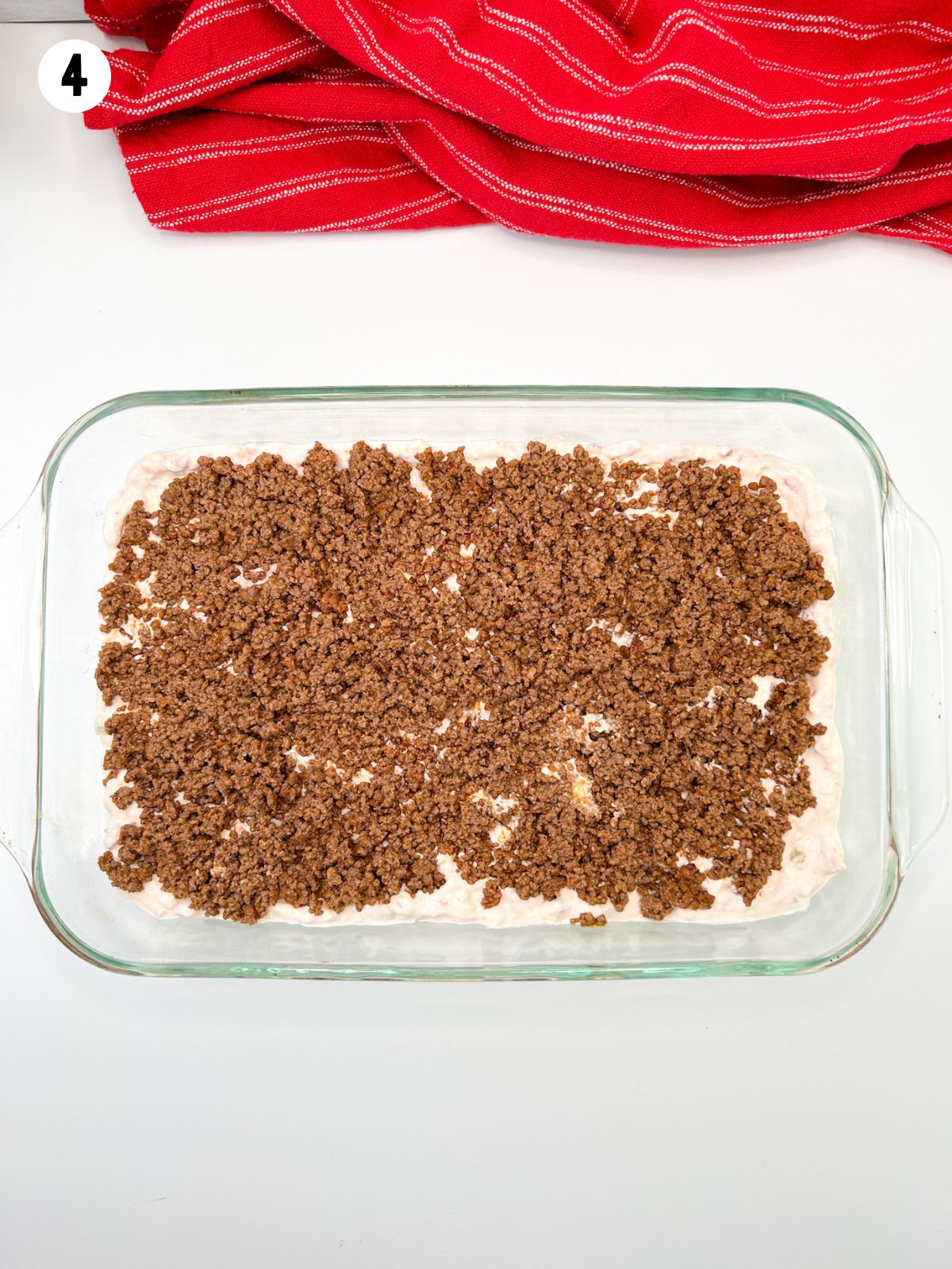 casserole dish with seasoned meat, cream cheese mixture.