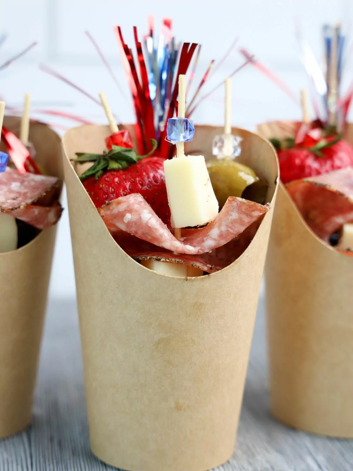 individual charcuterie cups filled with salami and cheese.