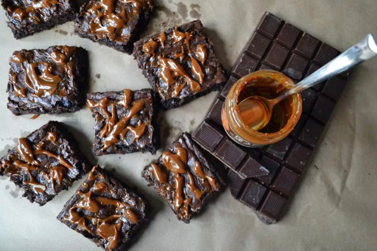 a stack of gooey brownies with dulce de leche sauce