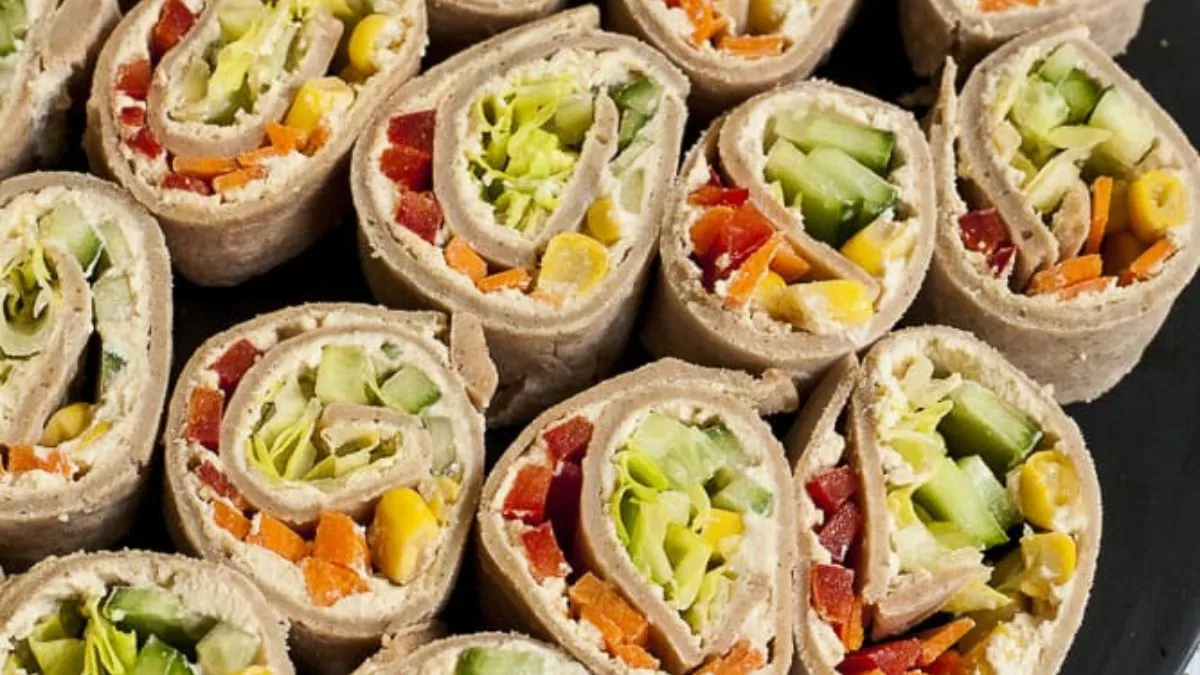 a platter of cream cheese and vegetable stuffed pinwheels.