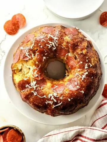 Pepperoni bread made in bundt pan baked on white plate.