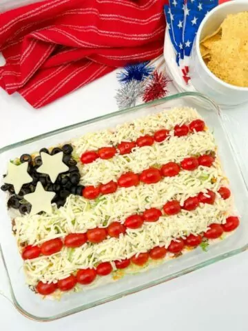 completed taco salad dip in casserole dish decorated like the American flag.