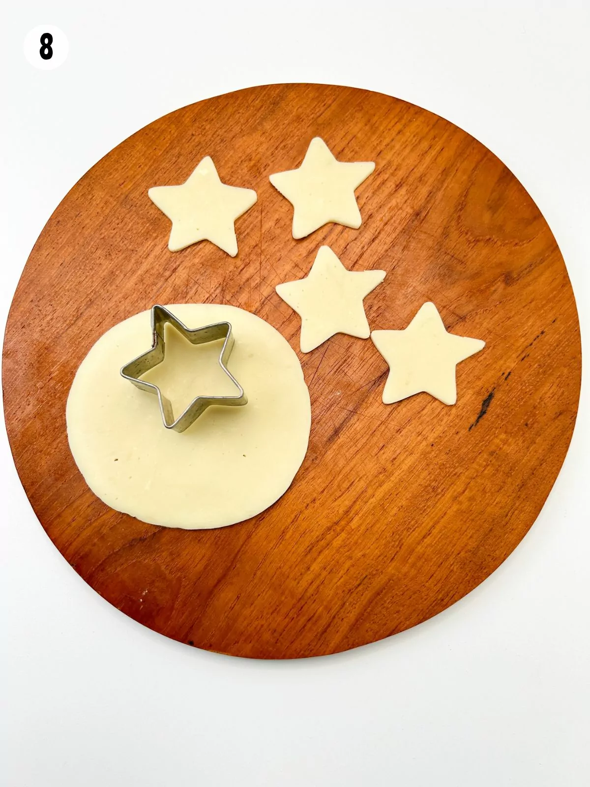 slice of cheese on cutting board with star shape cookie cutter.