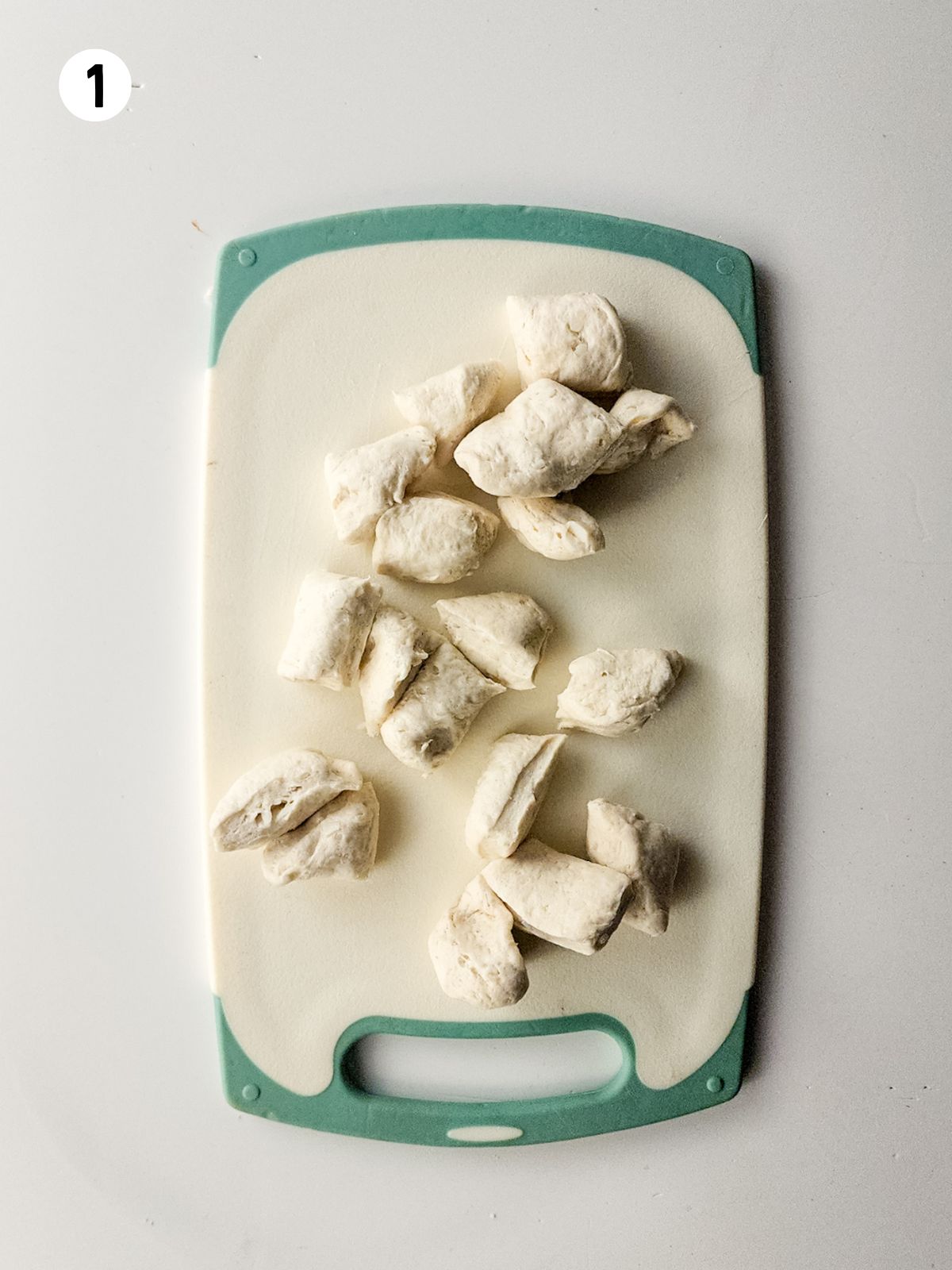 Grands refrigerated biscuits cut up on cutting board.