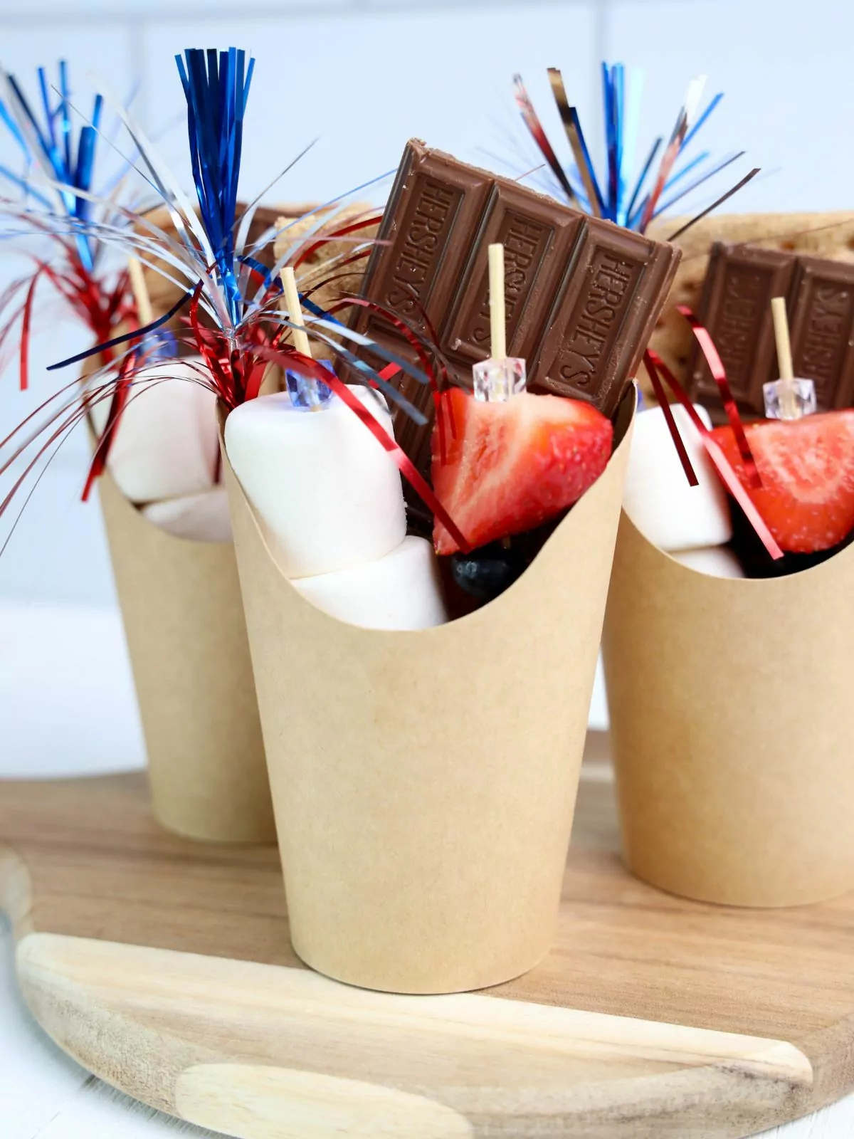 paper cups filled with everything you need to make a smore.