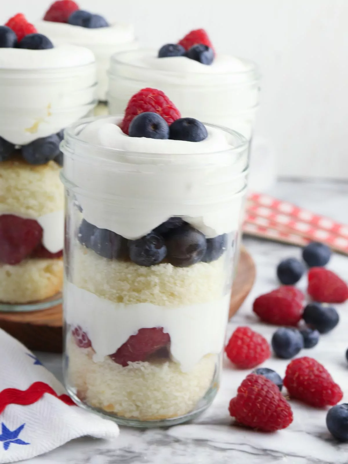 dessert in a jar topped with whipped cream and fresh berries.