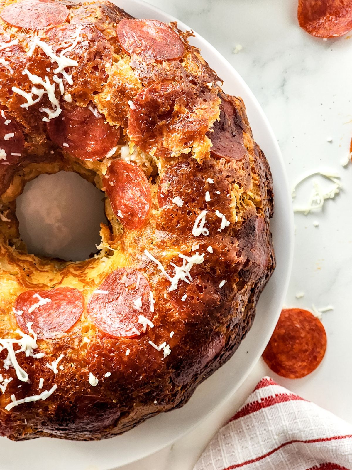 baked refrigerator biscuit dough with pepperoni slices on white plate.