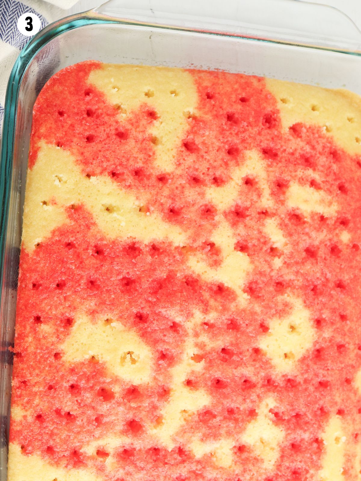 red Jello poked through baked cake.