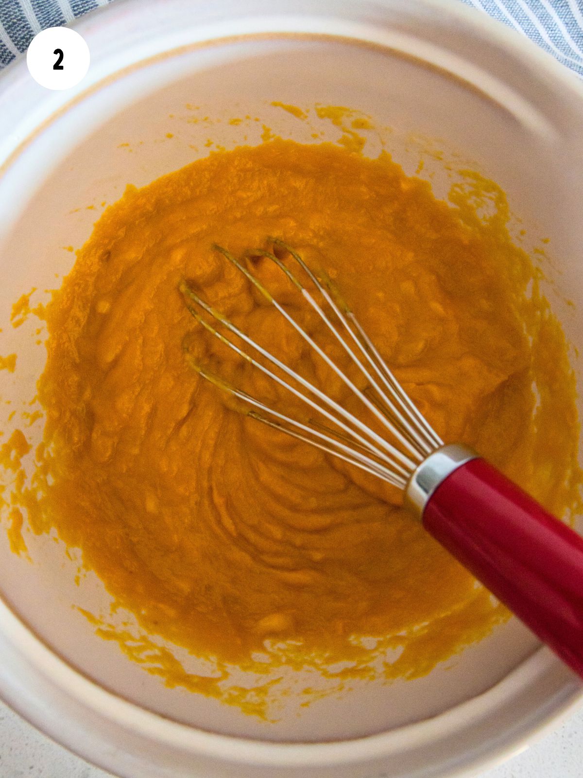 Pumpkin mixture in a mixing bowl with whisk