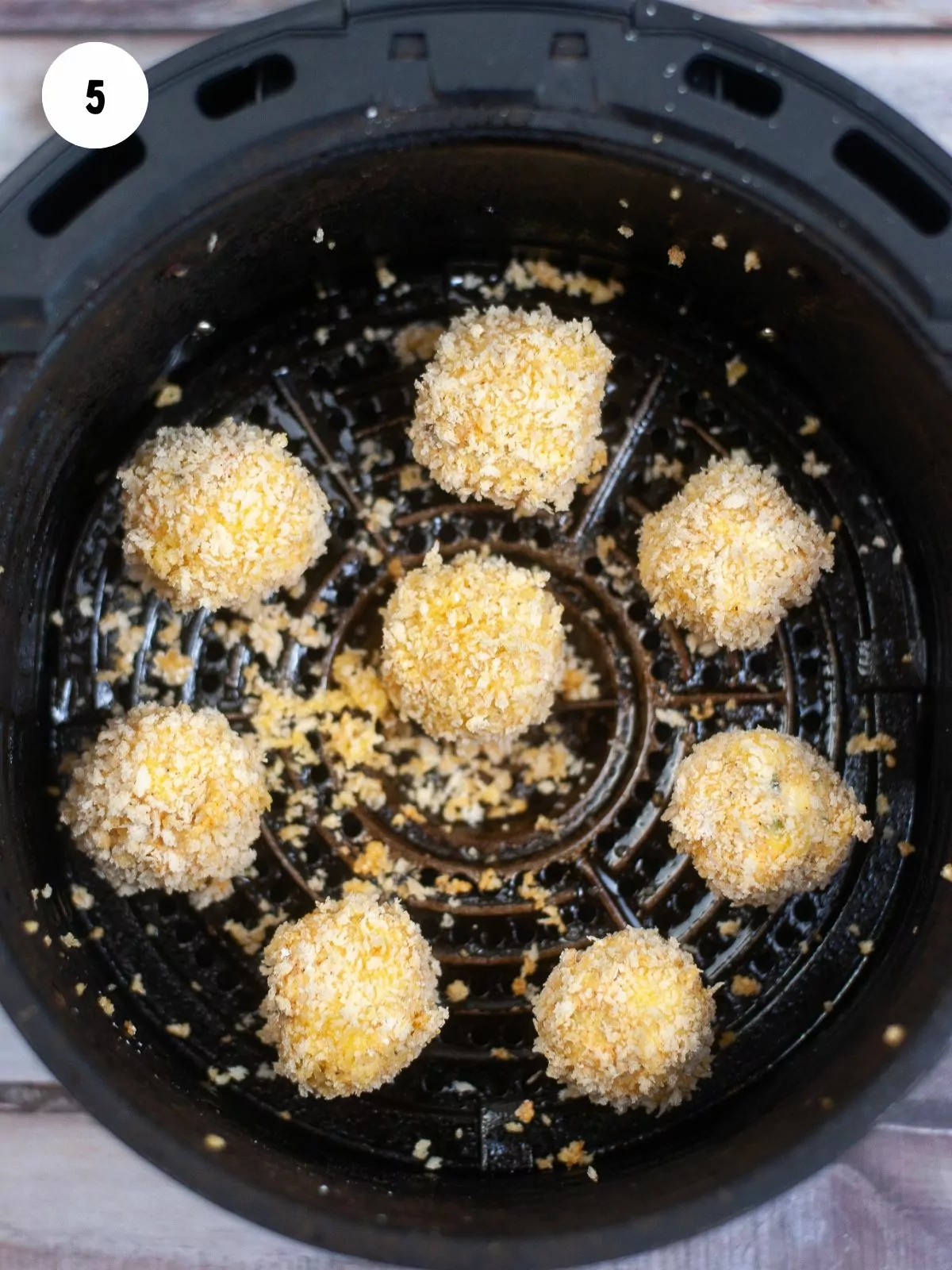 breaded jalapeno poppers added to the basket of the air fryer